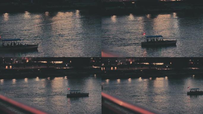 日落城市全景。河岸，水上渡轮