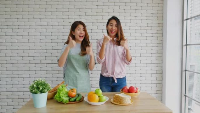 两名年轻的亚洲女性美食博主在录制视频进行广播时竖起大拇指并订阅，Vlog健康的生活方式