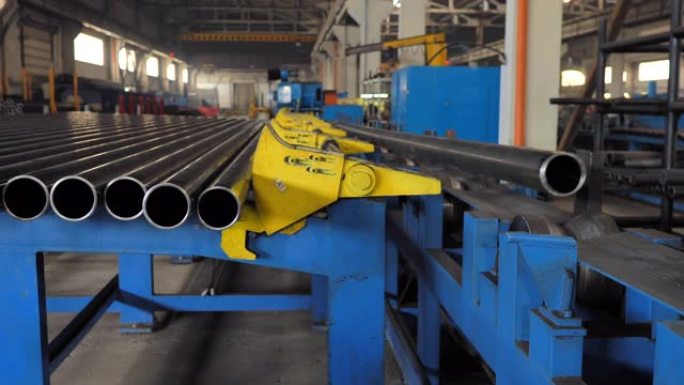 机器将金属管装载到生产线上。