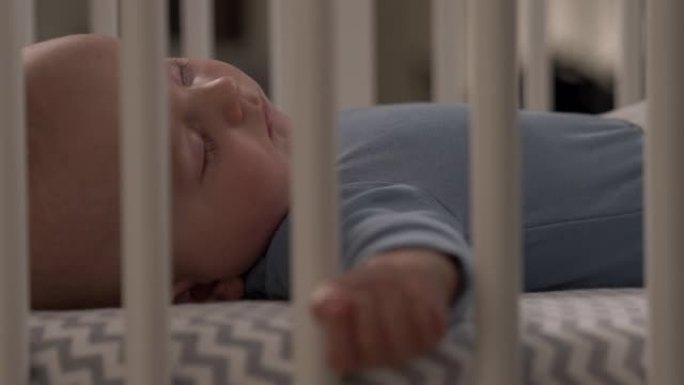 一个小男孩平静地睡在婴儿床里的特写视频。快乐的童年概念。感人时刻