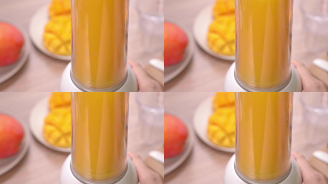 女人在明亮的木桌背景下在夏季厨房制作新鲜芒果汁。健康的自制概念。