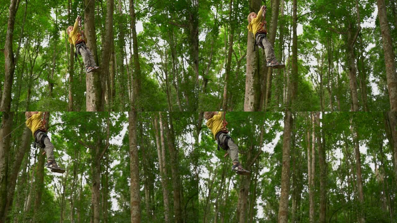 一个穿着安全带的小男孩的慢动作镜头在森林冒险公园的树梢上的滑索上攀爬。户外娱乐中心设有登山活动，包括
