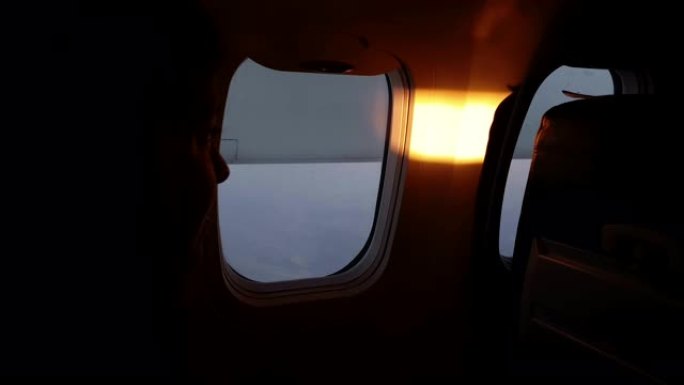 飞机上的女孩，看着早晨的阳光照进驾驶舱。飞机上温暖愉快的早晨