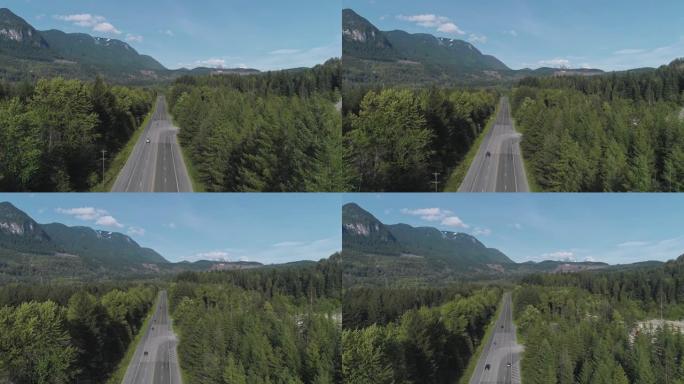 华盛顿州金条附近山区之间森林中繁忙的2号高速公路的鸟瞰图。无人机视频具有前进和上升的摄像机运动。
