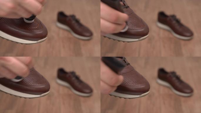 男性手握棕色皮革休闲鞋并用涂抹器用棕色奶油色抛光的特写视频