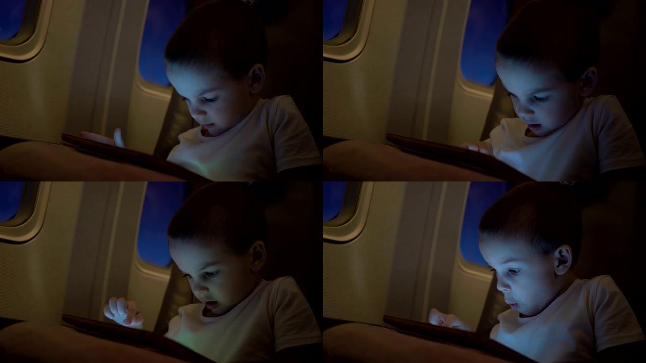 可爱的男孩坐飞机旅行，玩电脑平板电脑。超高清视频