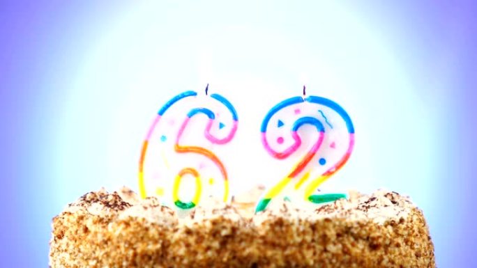 带有燃烧的生日蜡烛的生日蛋糕。62号。背景改变颜色
