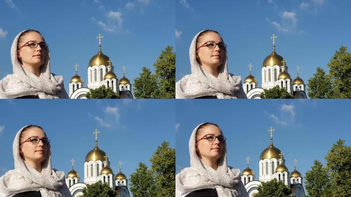 戴着围巾的东正教生活方式女人站在东正教教堂的背景下
