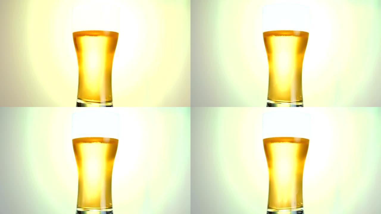 淡啤酒特写。一品脱冷光啤酒隔离在哑光黄色背景上旋转在白色背景上。