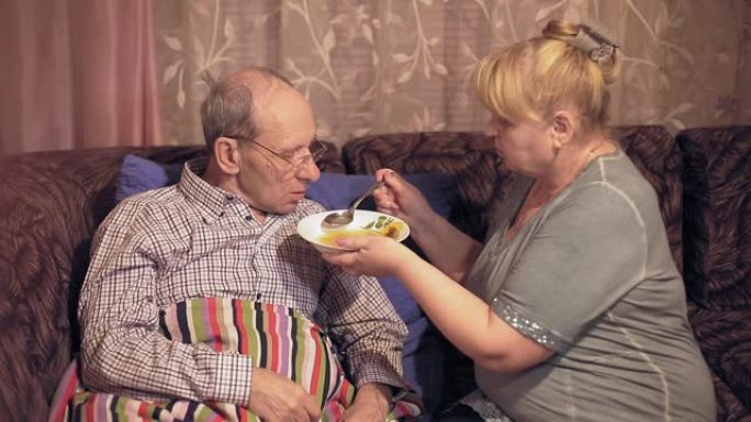 生活方式中年妻子照顾生病的丈夫并给他喂汤