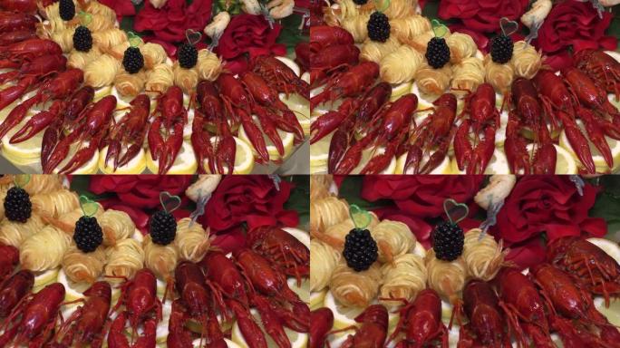 煮熟的小龙虾和蟹棒，水果放在托盘上