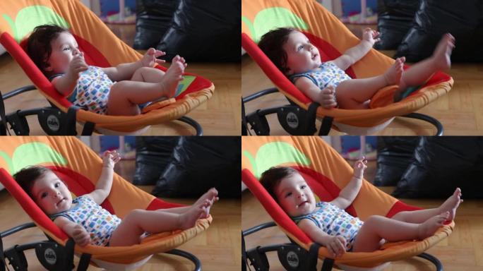 男婴躺在婴儿座椅上玩得开心