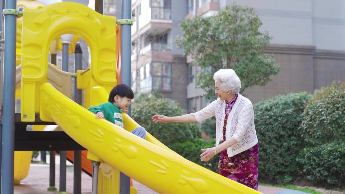 奶奶带孙子在小区游乐场玩滑梯送孩子上学