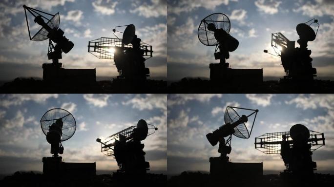 卫星天线或无线电天线对着夜空的轮廓。壮观的日落天空上空的太空天文台或防空雷达。创意艺术品装饰。选择性