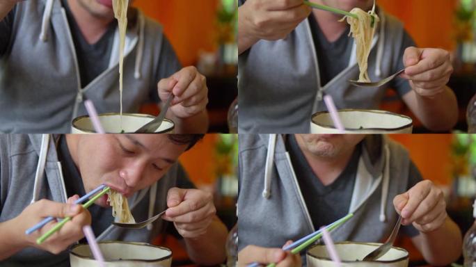 吃面条的亚洲男人。