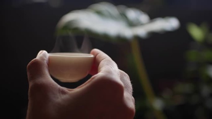 女人拿着小茶杯和中国乌龙茶。中国传统功夫或功夫茶道。中国传统文化的元素。特写。4k