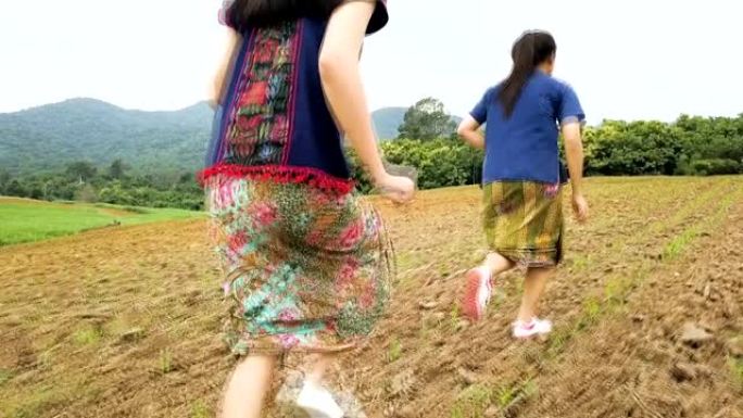美丽的亚洲年轻女孩在可爱的阳光明媚的夏日在玉米田里奔跑