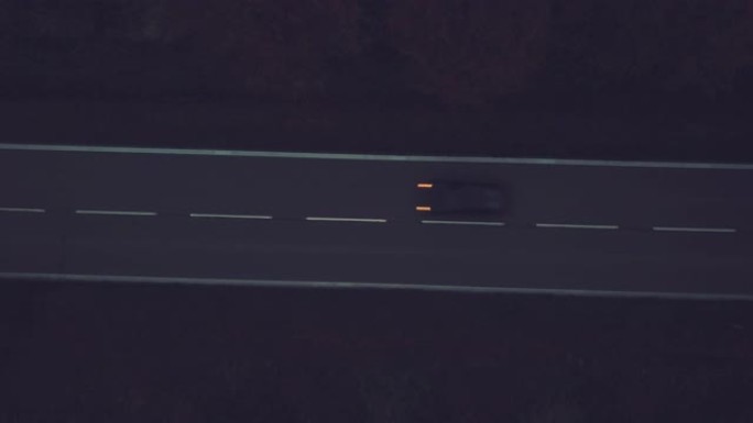 黄昏时在高速公路上的孤车，空中透视，背景为雾景。4K UHD