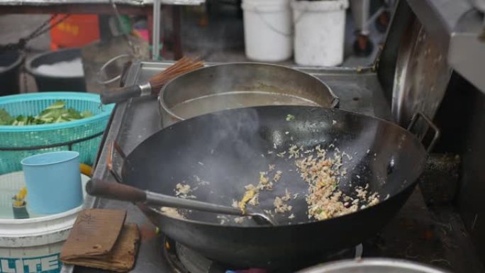 在当地街头市场用炒锅和蔬菜一起炒饭。4k
