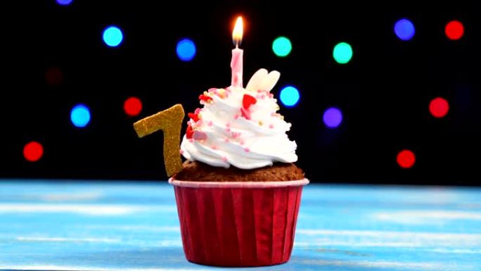 美味的生日蛋糕，蜡烛燃烧，彩色模糊灯光背景上有7号