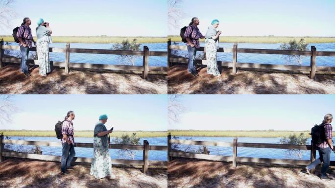 一对异性恋夫妇，男人和女人，用双目眼睛看着鸟，然后他们走了出去。北佛罗里达州Ochlockonee河