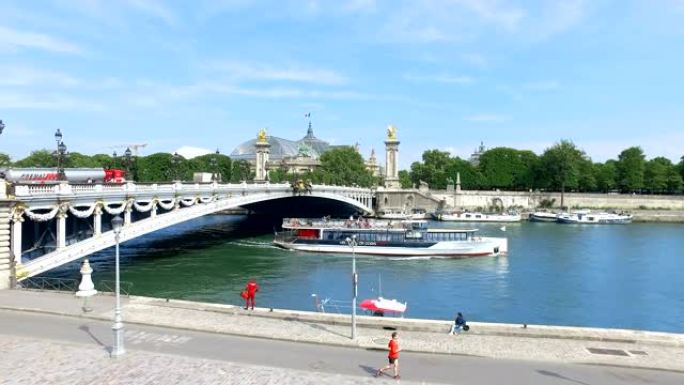 塞纳河上的交通船和巴黎亚历山大三世大桥上的汽车。晴天背景下的大皇宫 (大皇宫) 景观