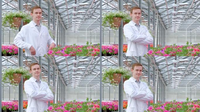 一个穿着白大褂的年轻人，科学家生物学家或农学家检查并分析了温室中的花朵和绿色植物。