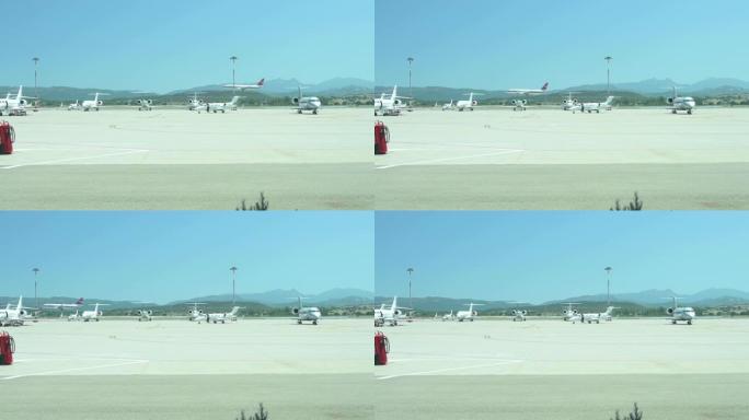 当一架商用飞机降落时，一些私人飞机停在撒丁岛机场的停车场上，令人惊叹。意大利撒丁岛。