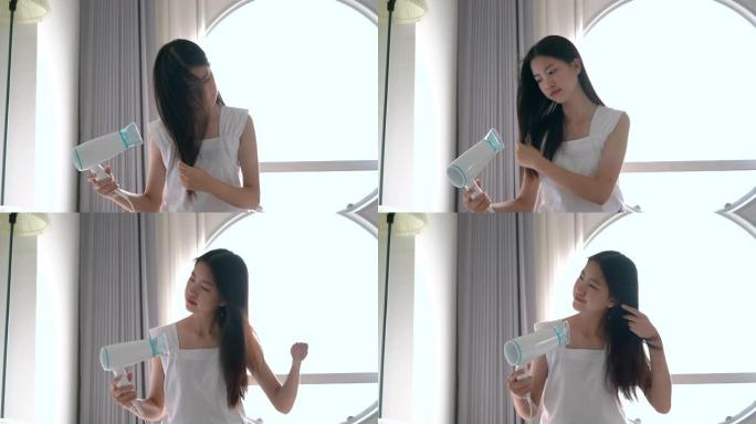 年轻漂亮的亚洲女人早上在酒店房间洗完澡后在床上用吹风机。