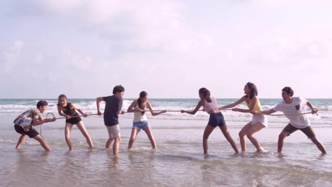 一群朋友在海滩上玩绳子时玩得很开心。