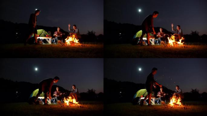 一群青少年的场景慢动作亚洲背包客在暑假期间在湖边享受篝火和野餐。他们很开心，在假期放松的时刻也很开心
