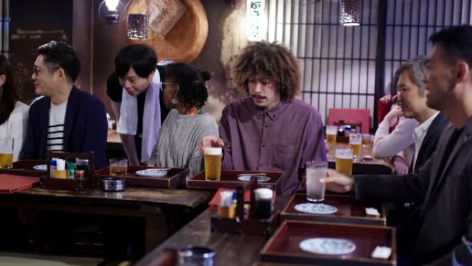 游客在日本居酒屋看菜单