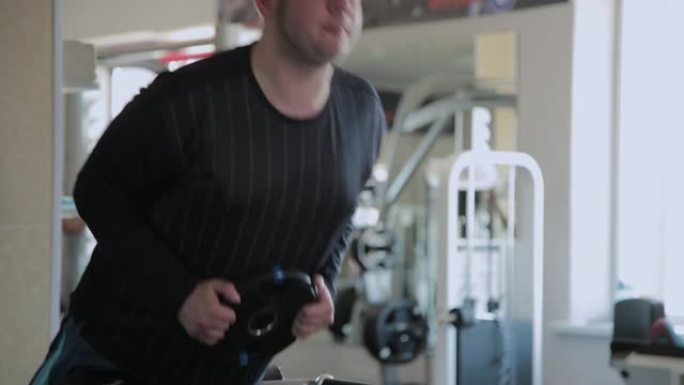 超重的成年男子在健身房进行过度伸展