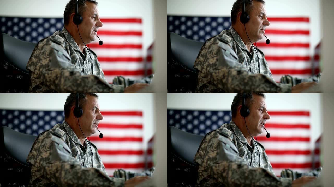 一名身穿美军制服的高级男子戴着耳机和麦克风讲话