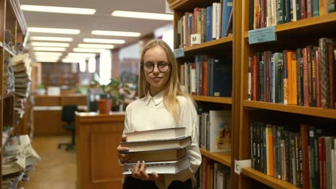 美丽的女学生在大学图书馆消费休息。寻找必要的文学课程。站在书架附近。