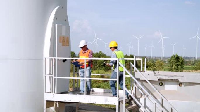 技术人员检查风力涡轮机的状况并向电气工程师报告。