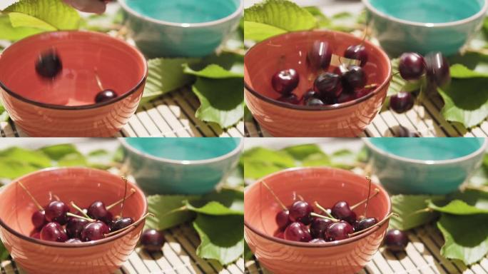 甜樱桃落在陶瓷碗里，慢动作。樱桃特写。新鲜的夏季浆果。健康食品概念。