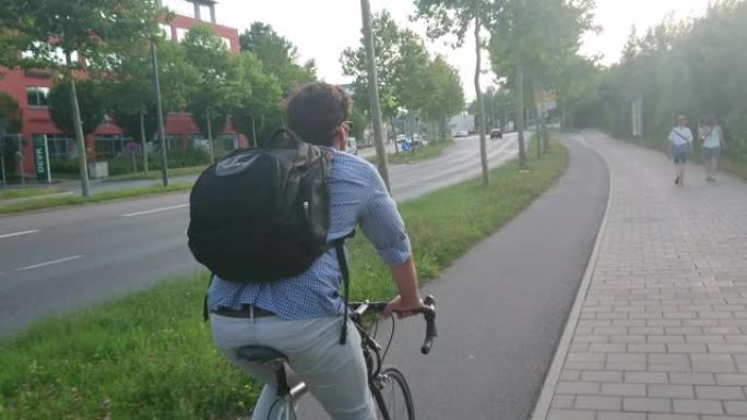 年轻的成年男子在德国雷根斯堡拉蒂斯博纳骑自行车，背着背包