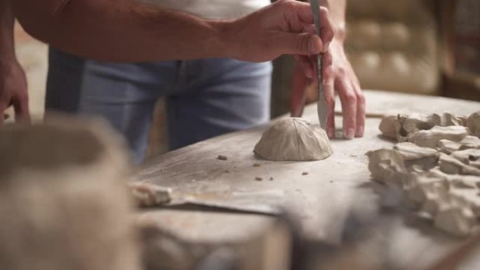专业陶工使用特殊工具处理陶瓷粘土，并向学生展示他的作品。老师与他的追随者概念一起工作。