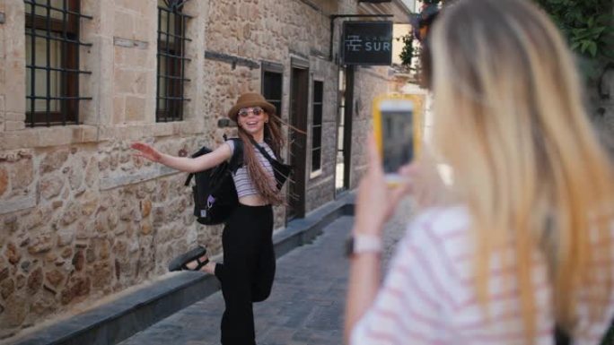 旅游旅游女友在欧洲老城笑着用智能手机拍照
