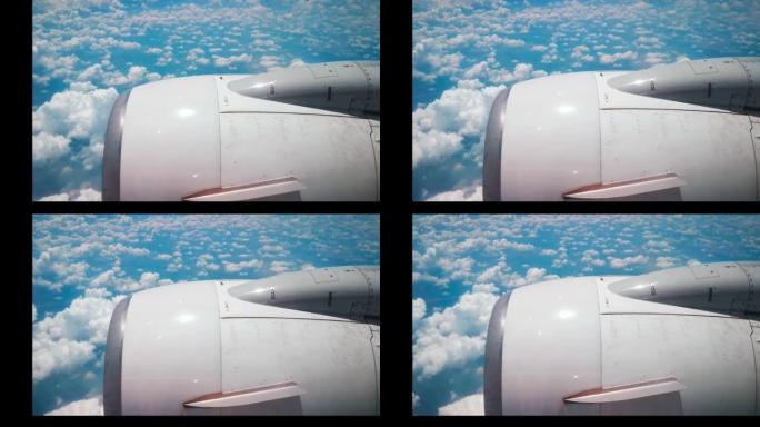飞机飞行。飞机的机翼在云层上飞来飞去，天空多云。从飞机的窗户看。