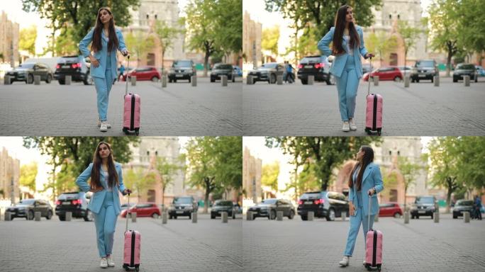 女人带着手提箱在城市等待出租车