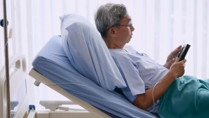 老人躺在病人床上时拿着带有家人照片的相框