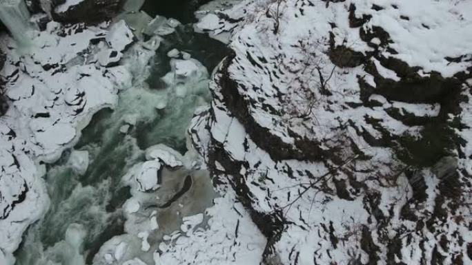 带着河流和冰冻的瀑布下降到峡谷的地面