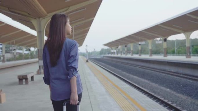 亚洲女子拖着包去火车