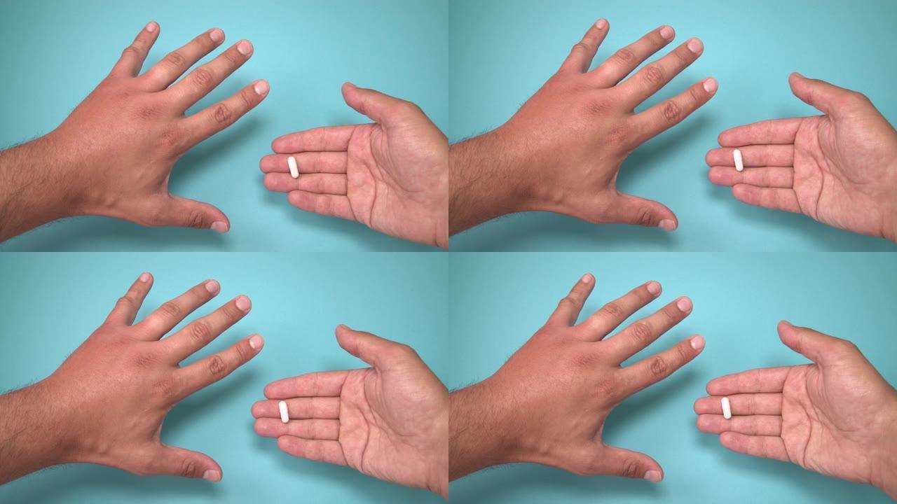 雄性的手被蜜蜂和药物在其旁边肿胀。手部肿胀、发炎、发红是感染的征兆。蓝色背景上的昆虫叮咬和药丸