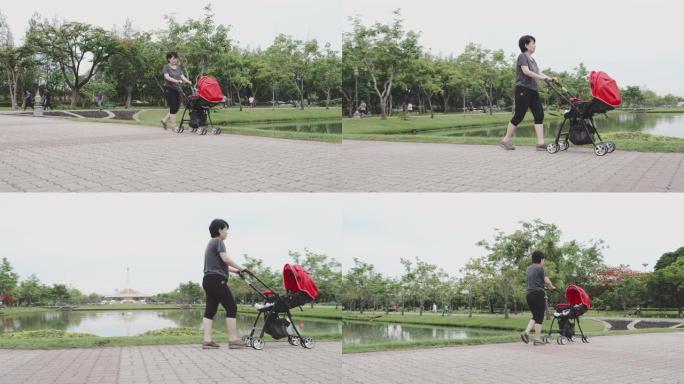 婴儿; 母亲在婴儿车里走路和推着男婴。