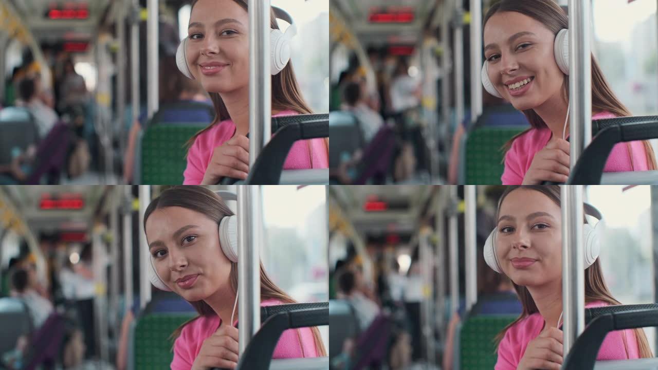 一位年轻女性乘客在公共交通工具上享受旅行的肖像，戴着耳机坐在现代电车上。
