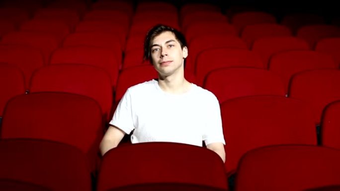 一个人独自坐在空荡荡的电影院或剧院里