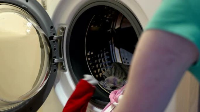 女人拿出洗衣机洗干净的衣服。